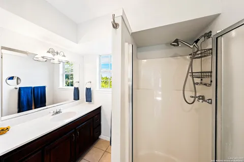 a bathroom with a double vanity sink mirror and shower