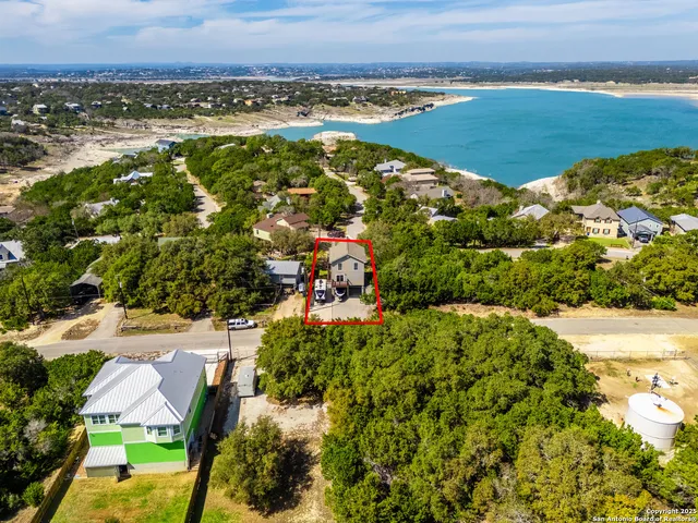 an aerial view of residential houses with outdoor space and river