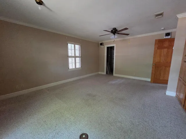 an empty room with a window and a ceiling fan