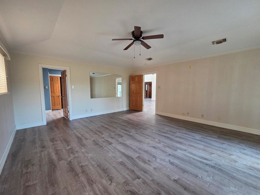 2212 Rock Creek Drive Kerrville, TX 78028 - Photo 16 of 36 a view of empty room with wooden floor and ceiling fan