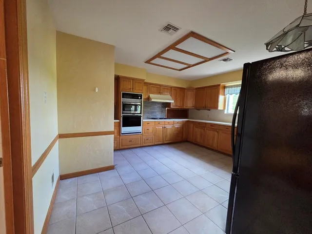 a kitchen with granite countertop a refrigerator and a sink