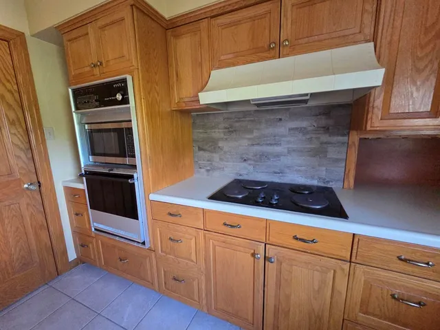 a kitchen with granite countertop white cabinets and stainless steel appliances