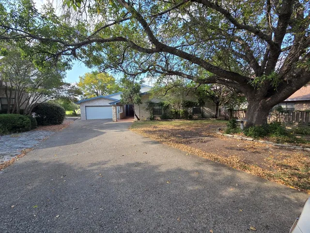 a view of a house with a large tree