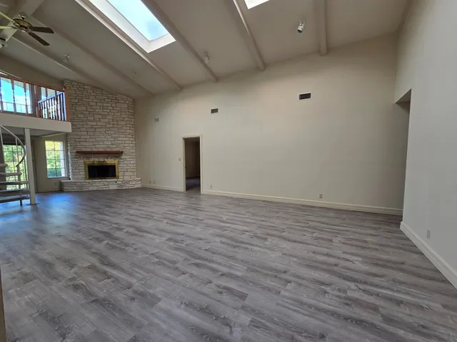 an empty room with wooden floor and fireplace