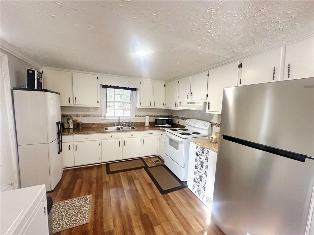 158 Rabbit Hill Road Dacula, GA 30019 - Photo 21 of 64 a kitchen with white cabinets and white appliances