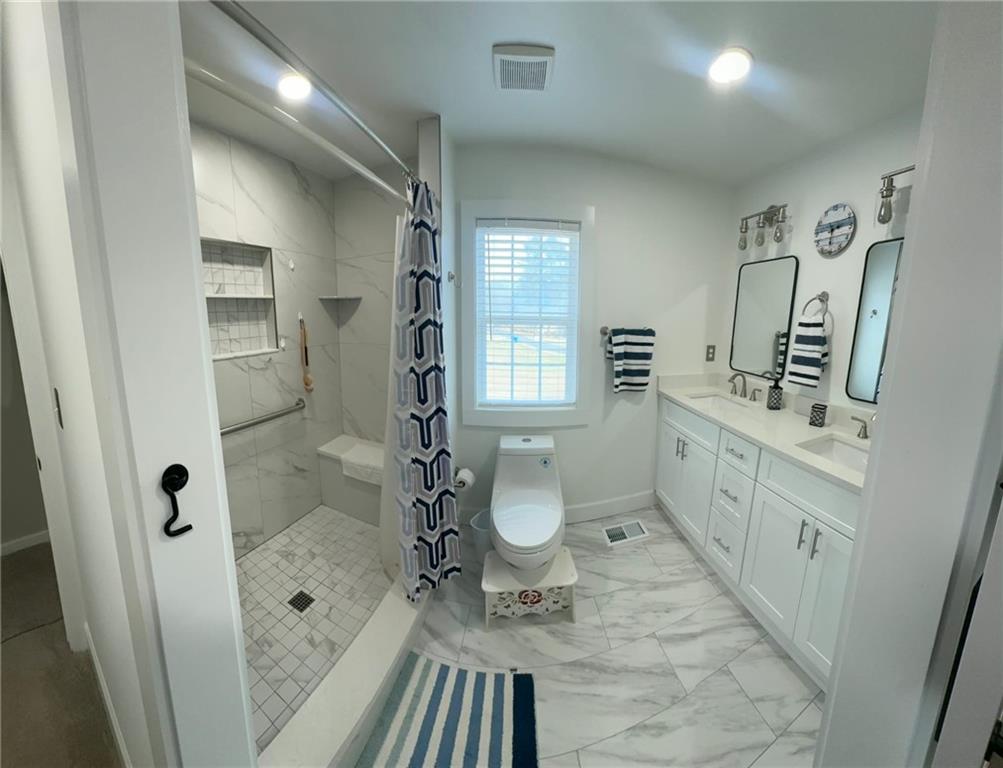 158 Rabbit Hill Road Dacula, GA 30019 - Photo 29 of 64 a bathroom with a double vanity sink toilet mirror and shower