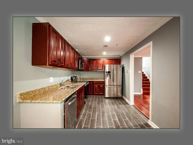 a kitchen with granite countertop a sink and a wooden cabinets