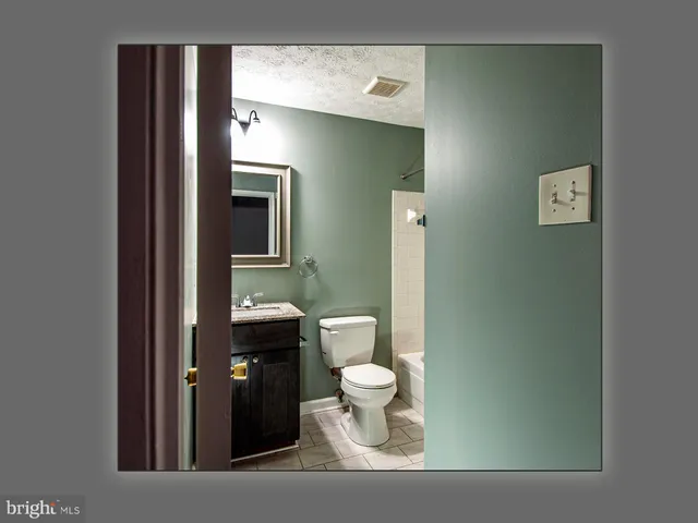 a view of a hallway with wooden floor and a living room