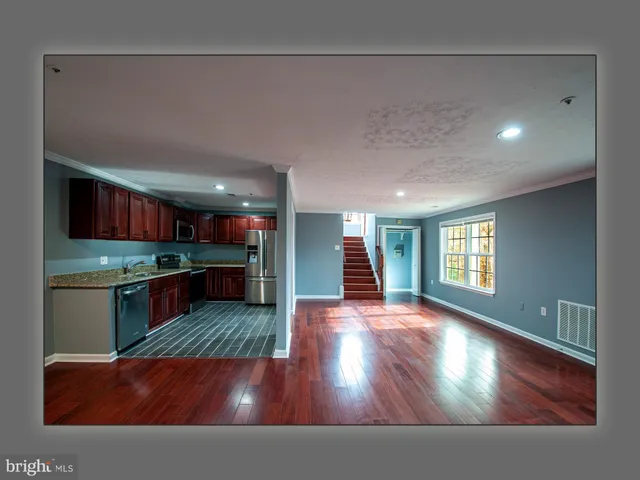 a kitchen view with wooden floor and large windows