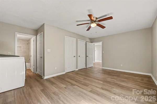 a view of empty room with wooden floor and ceiling fan