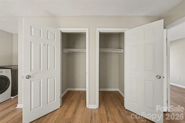 a view of walk in closet with wooden floor