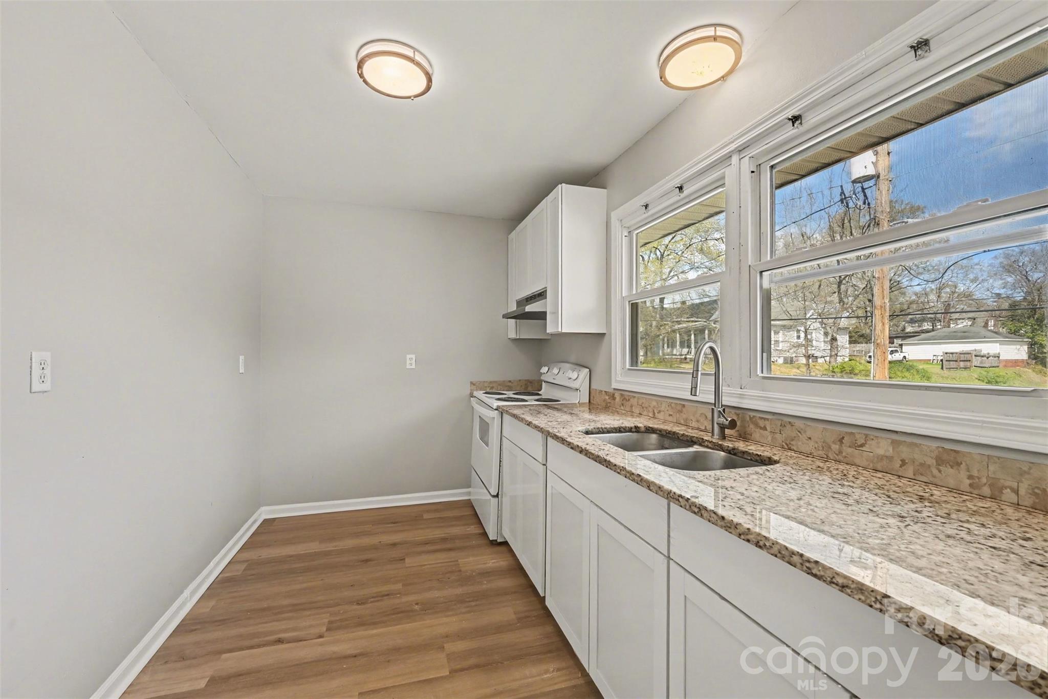 270-272 Spring Street Southwest Concord, NC 28025 - Photo 17 of 26 a kitchen with granite countertop a sink and a window