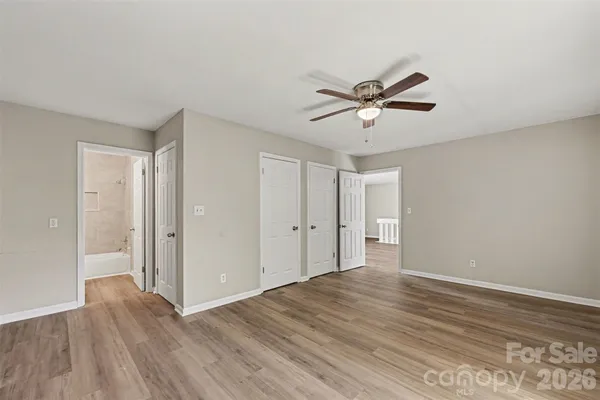 a view of a room with wooden floor and a ceiling fan