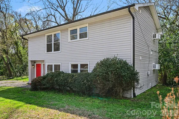 a view of a house with a yard and potted plants