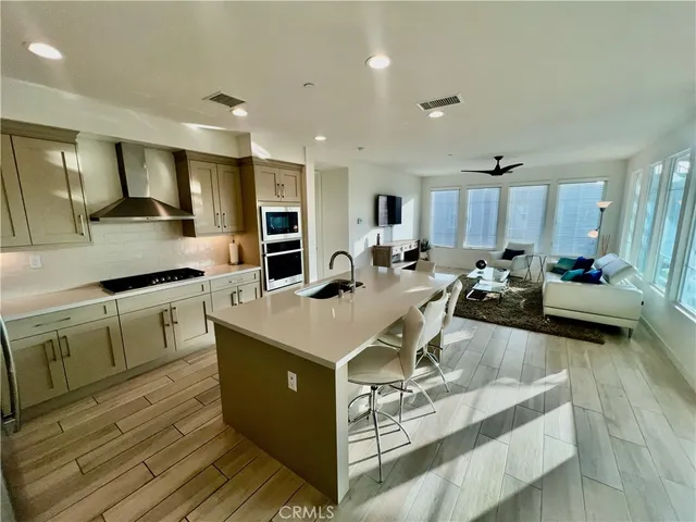 a large white kitchen with stainless steel appliances kitchen island granite countertop a sink and cabinets