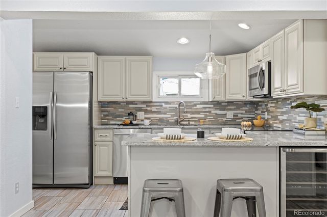 a kitchen with stainless steel appliances a refrigerator sink and cabinets
