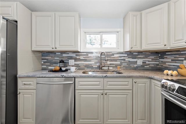 a kitchen with white cabinets and white appliances