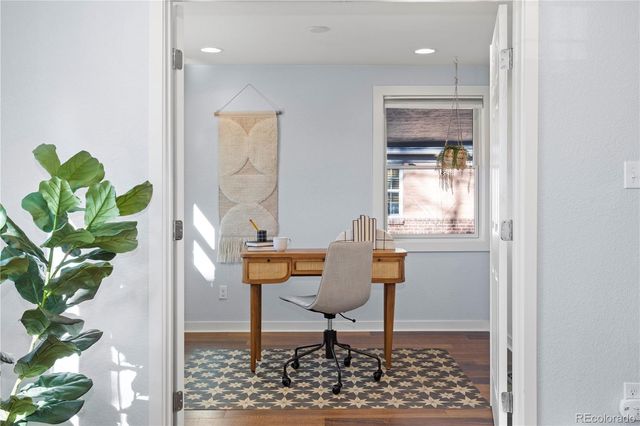 a workspace room with wooden floor and a potted plant