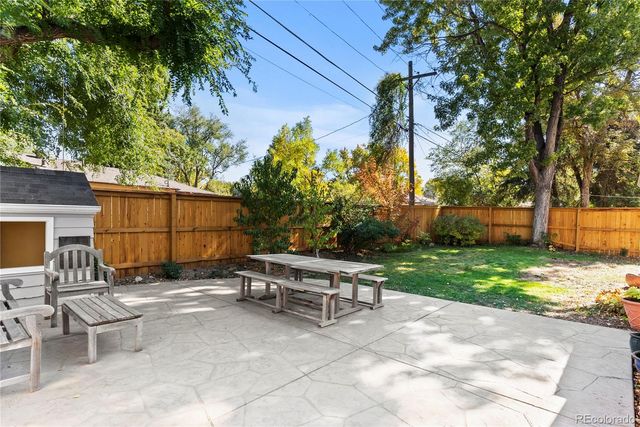 a view of backyard with a table and chairs and potted plants