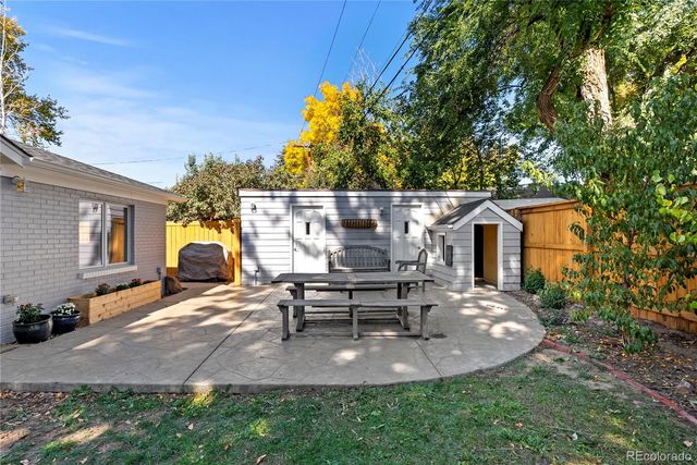 a view of a patio with table and chairs with wooden fence and plants