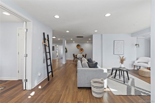 a living room with furniture and a wooden floor