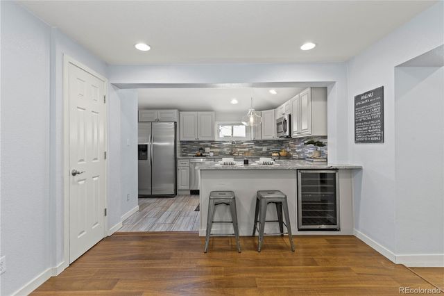 a view of kitchen with stainless steel appliances granite countertop a stove and a refrigerator