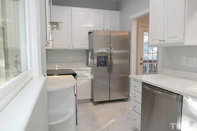 a kitchen with stainless steel appliances granite countertop a refrigerator sink and cabinets