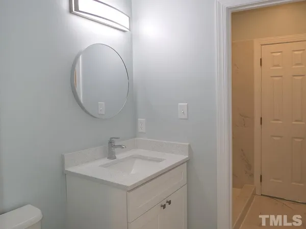 a bathroom with a sink a toilet and a mirror