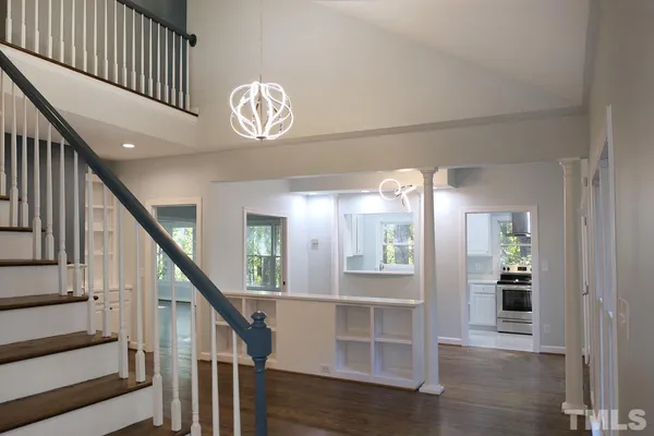 a view of a hallway with wooden floor and staircase