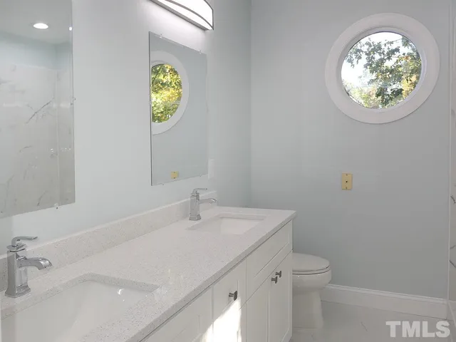 a bathroom with a sink a toilet and a mirror