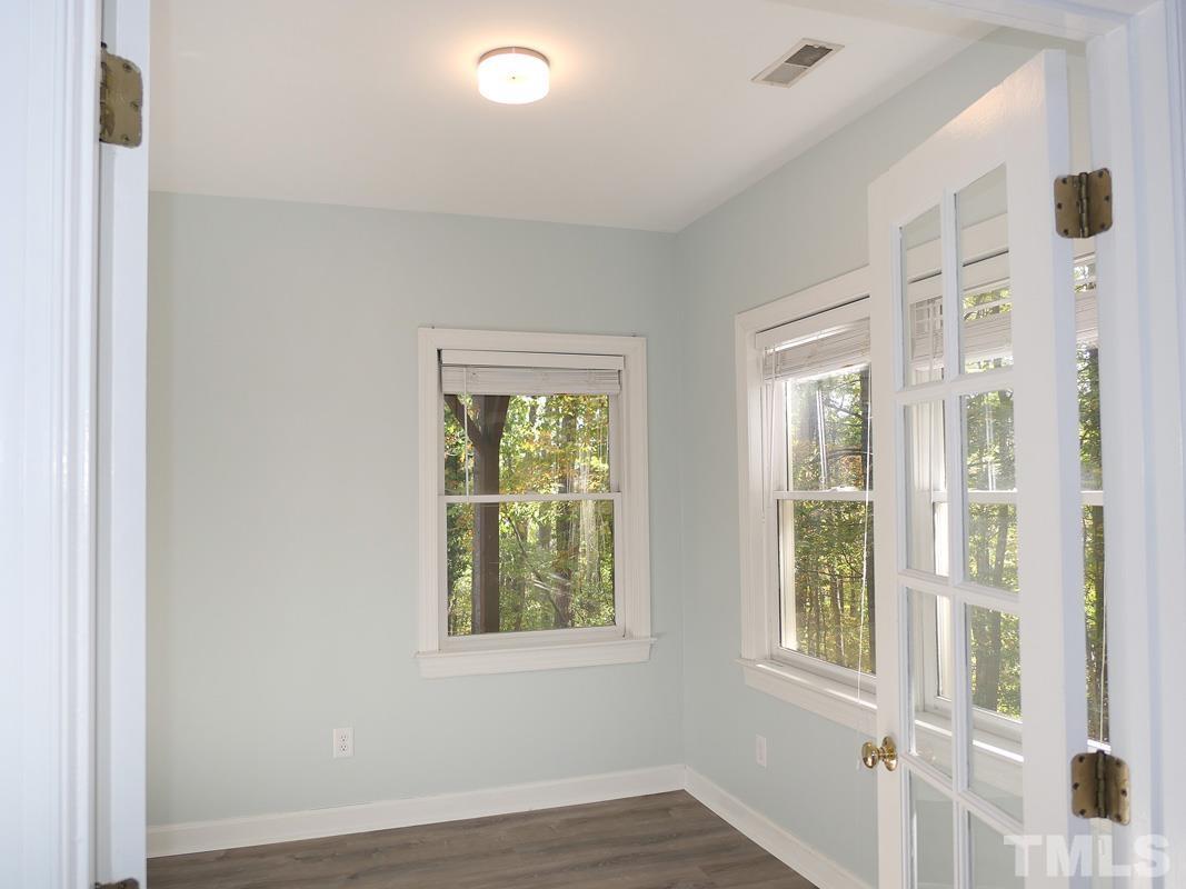 304 Columbia Place East Chapel Hill, NC 27516 - Photo 27 of 34 an empty room with wooden floor and windows