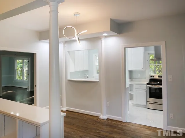 a view of a hallway with wooden floor and a living room