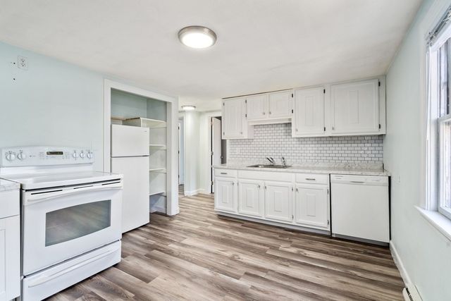 a kitchen with granite countertop white cabinets and white appliances