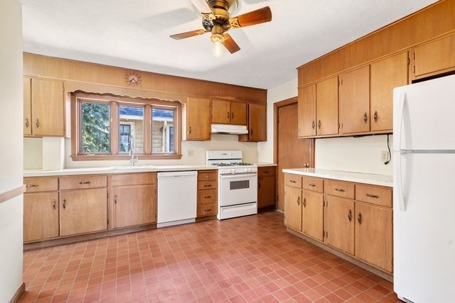 a kitchen with granite countertop white cabinets and white appliances
