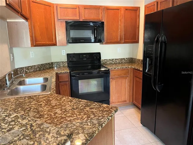 a kitchen with stainless steel appliances granite countertop a refrigerator stove and microwave