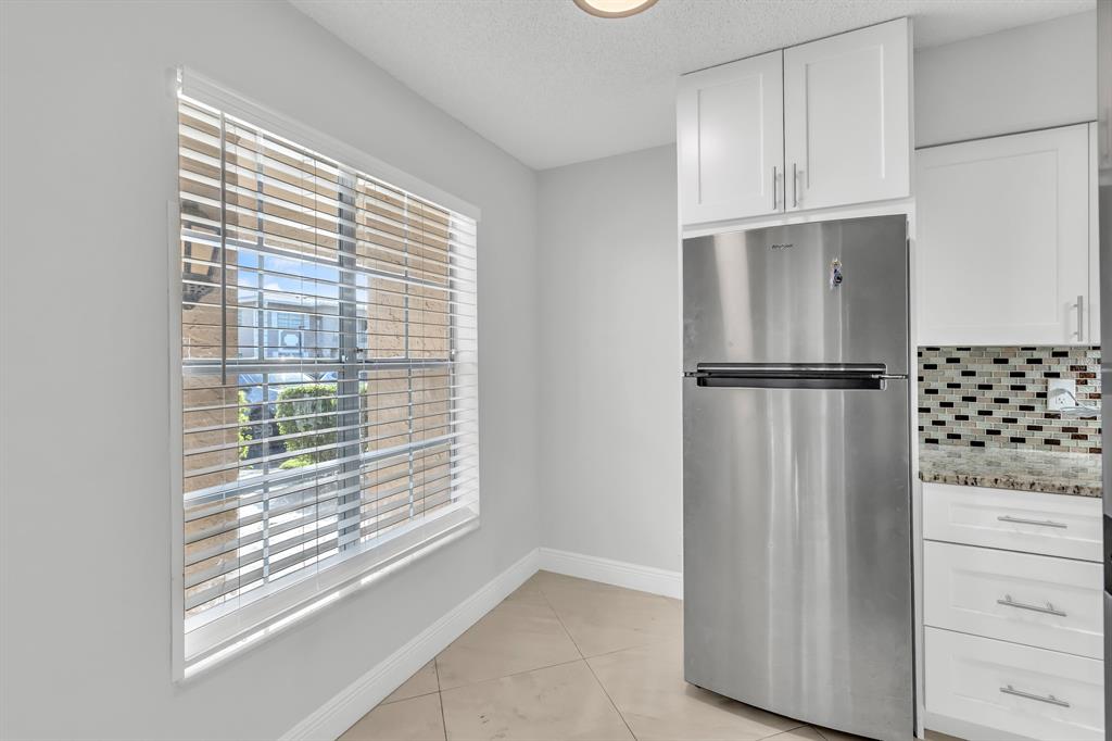 13950 Vía Flora, Unit B Delray Beach, FL 33484 - Photo 2 of 28 a view of kitchen with cabinets and refrigerator