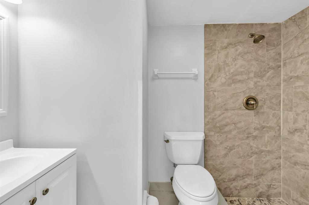 13950 Vía Flora, Unit B Delray Beach, FL 33484 - Photo 6 of 28 a white toilet sitting next to a bathroom sink