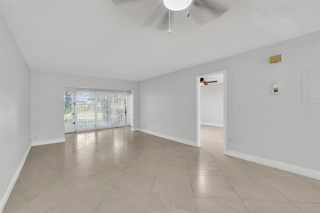 13950 Vía Flora, Unit B Delray Beach, FL 33484 - Photo 8 of 28 a view of an empty room with wooden floor and a window