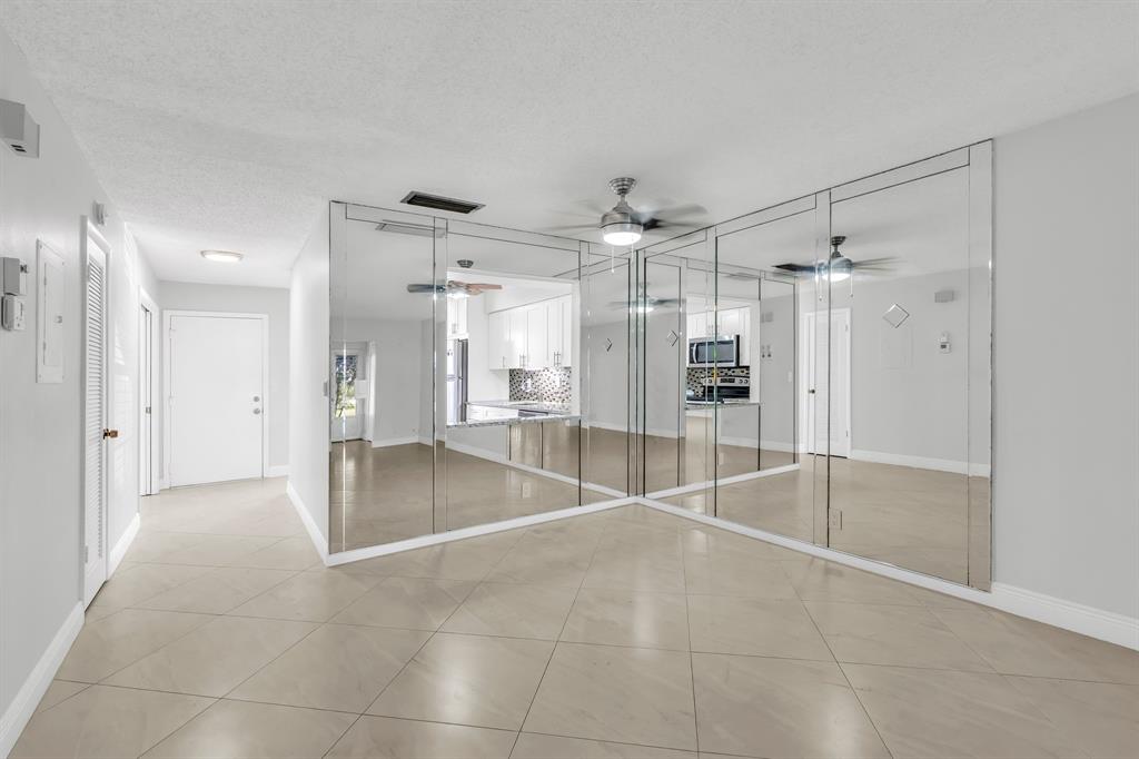 13950 Vía Flora, Unit B Delray Beach, FL 33484 - Photo 10 of 28 a view of an empty room with a cabinet and mirrors