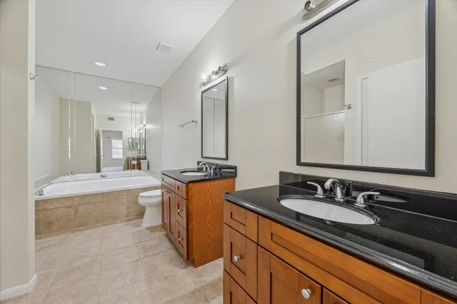 a bathroom with double vanity sinks double vanity tub and a mirror