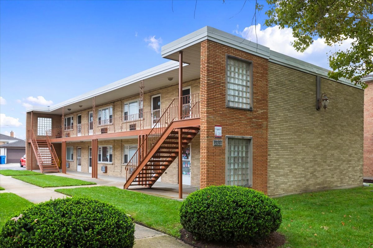 6250 West 64th Place, Unit 103 Chicago, IL 60638 - Photo 2 of 28 a front view of a house with a yard