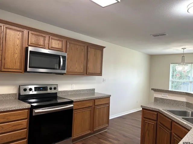 a kitchen with stainless steel appliances granite countertop a stove a microwave and oven