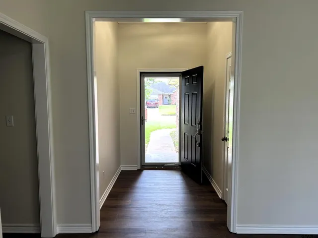 a view of a hallway with wooden floor