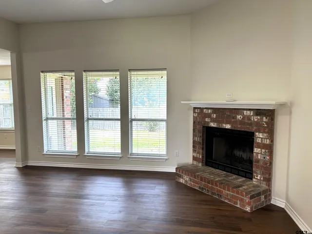 an empty room with floor to ceiling window and fireplace