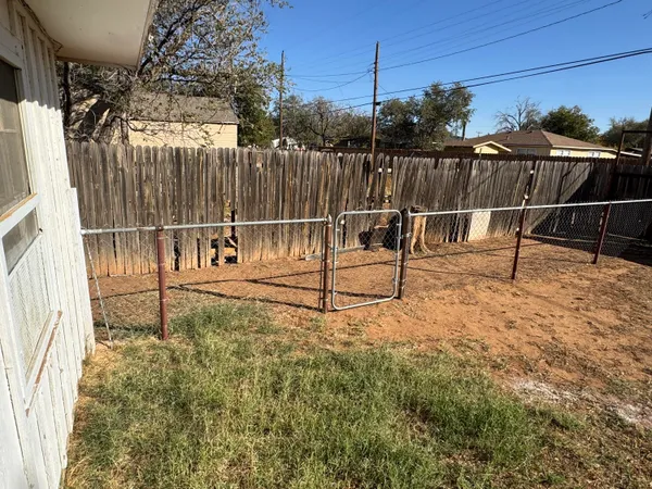 a view of a backyard with wooden fence