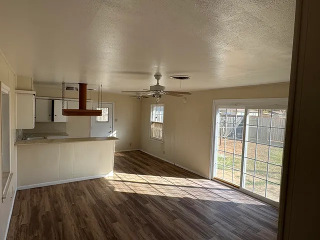 a view of a kitchen with wooden floor and a window