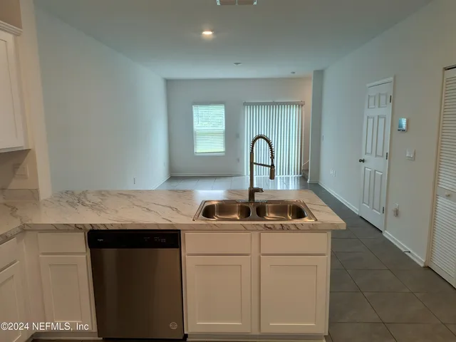 a kitchen with a sink a stove and cabinets