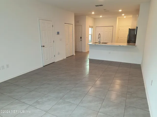 a view of a kitchen with kitchen island white cabinets and stainless steel appliances