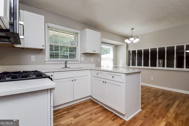 a kitchen with a stove a sink and a window