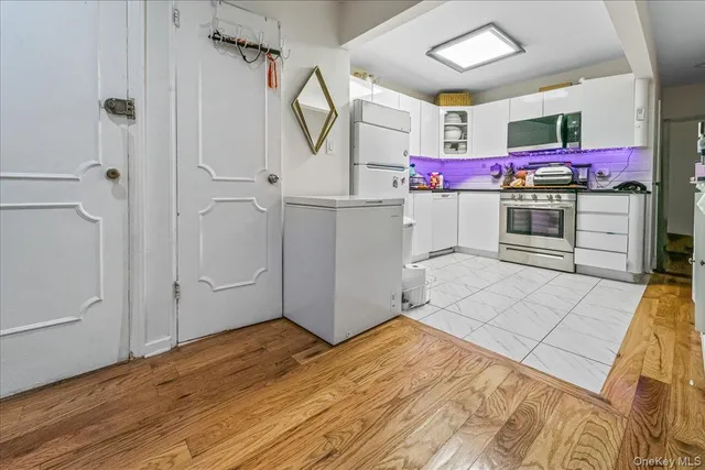 a kitchen with stainless steel appliances cabinets and wooden floor